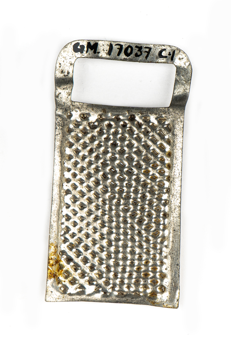 Rivjärn, 1-3, av vitmetall. En rektangulär skiva välvd.
Ytan fylld av rivtaggar. upptill ett format handtag.
1 och 2 är större än 3.

Tillhör leksakssamling GM17037a-k.