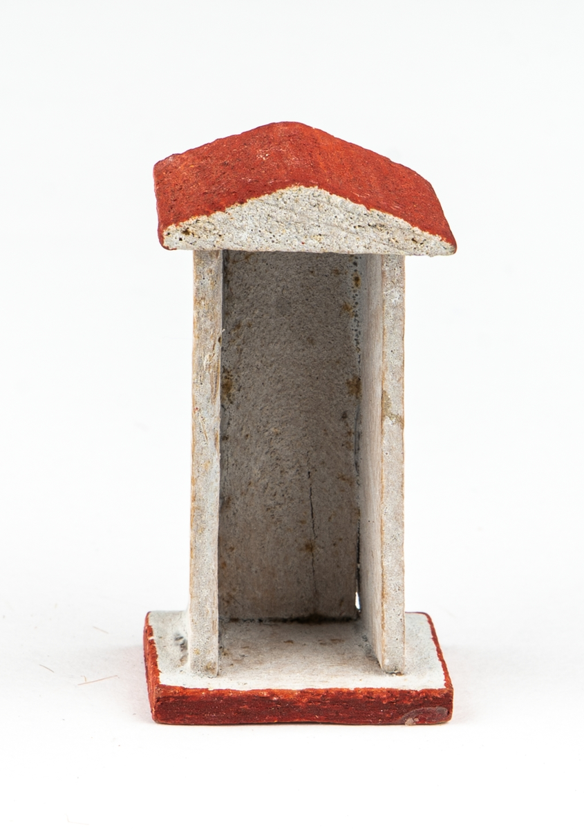 Vaktkur av trä med lös soldat. Fyra kurar, 20 soldater. Kuren ljusgrå med rödbrunt sadeltak och fotplatta med brun kant. På sidorna rund röd fläck markerande fönsterglugg. Soldaten i grå uniform med vita knappar, "rundkullig" hjälm och bruna stövlar. Gevär. Kurar och soldater skiljer sig något i utförandet. 2 soldater har tappat geväret, en saknar fotplatta.