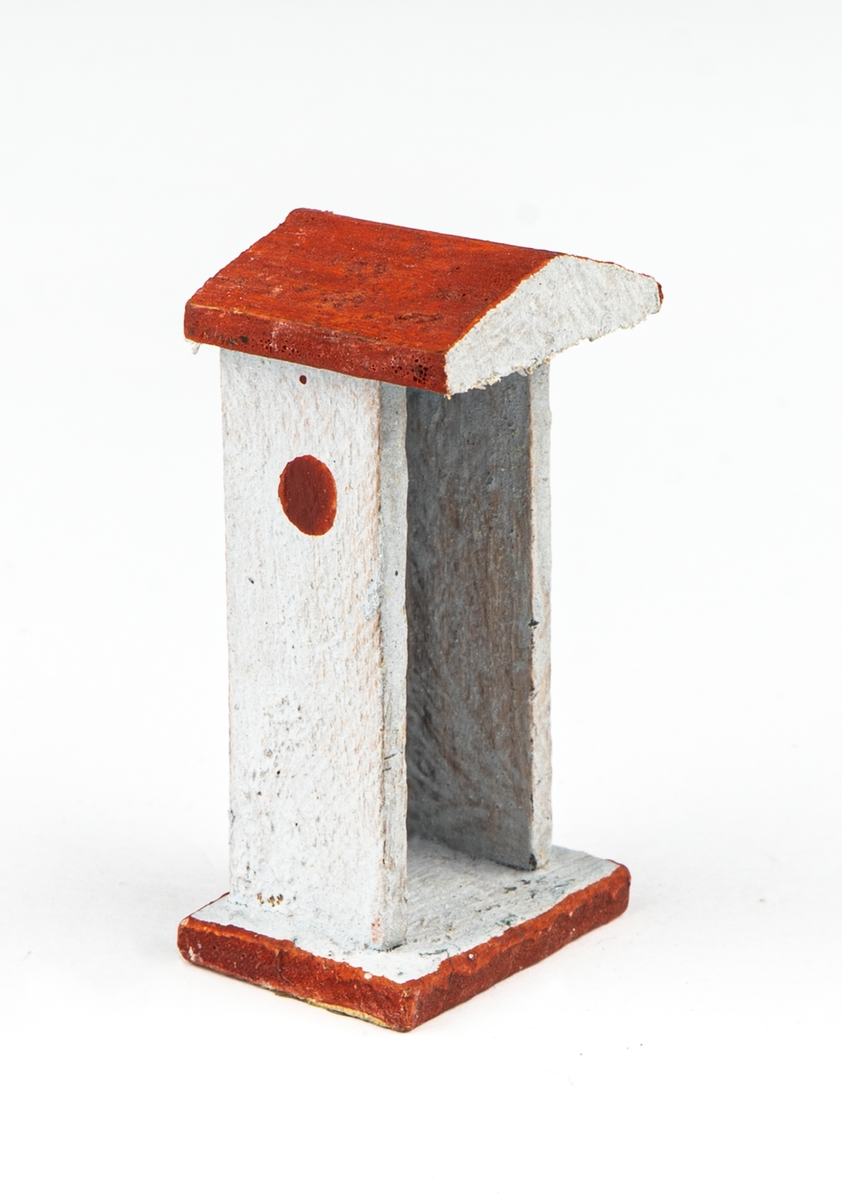 Vaktkur av trä med lös soldat. Fyra kurar, 20 soldater. Kuren ljusgrå med rödbrunt sadeltak och fotplatta med brun kant. På sidorna rund röd fläck markerande fönsterglugg. Soldaten i grå uniform med vita knappar, "rundkullig" hjälm och bruna stövlar. Gevär. Kurar och soldater skiljer sig något i utförandet. 2 soldater har tappat geväret, en saknar fotplatta.