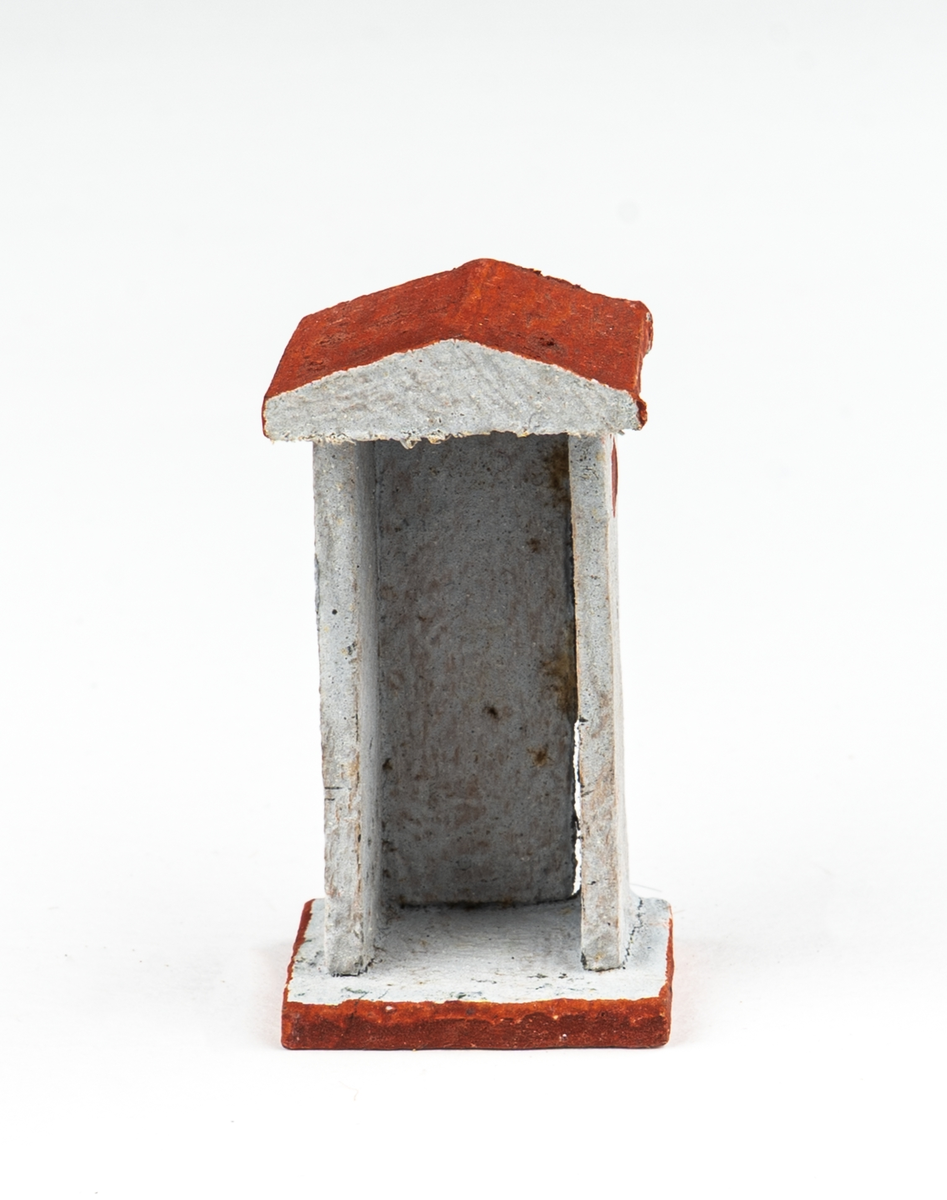 Vaktkur av trä med lös soldat. Fyra kurar, 20 soldater. Kuren ljusgrå med rödbrunt sadeltak och fotplatta med brun kant. På sidorna rund röd fläck markerande fönsterglugg. Soldaten i grå uniform med vita knappar, "rundkullig" hjälm och bruna stövlar. Gevär. Kurar och soldater skiljer sig något i utförandet. 2 soldater har tappat geväret, en saknar fotplatta.