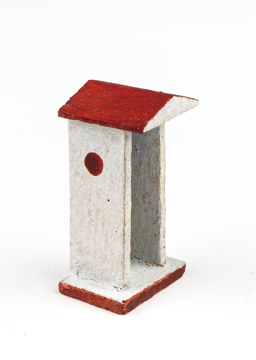 Vaktkur av trä med lös soldat. Fyra kurar, 20 soldater. Kuren ljusgrå med rödbrunt sadeltak och fotplatta med brun kant. På sidorna rund röd fläck markerande fönsterglugg. Soldaten i grå uniform med vita knappar, "rundkullig" hjälm och bruna stövlar. Gevär. Kurar och soldater skiljer sig något i utförandet. 2 soldater har tappat geväret, en saknar fotplatta.