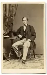 Porträtt på en man i helfigur , sittande.