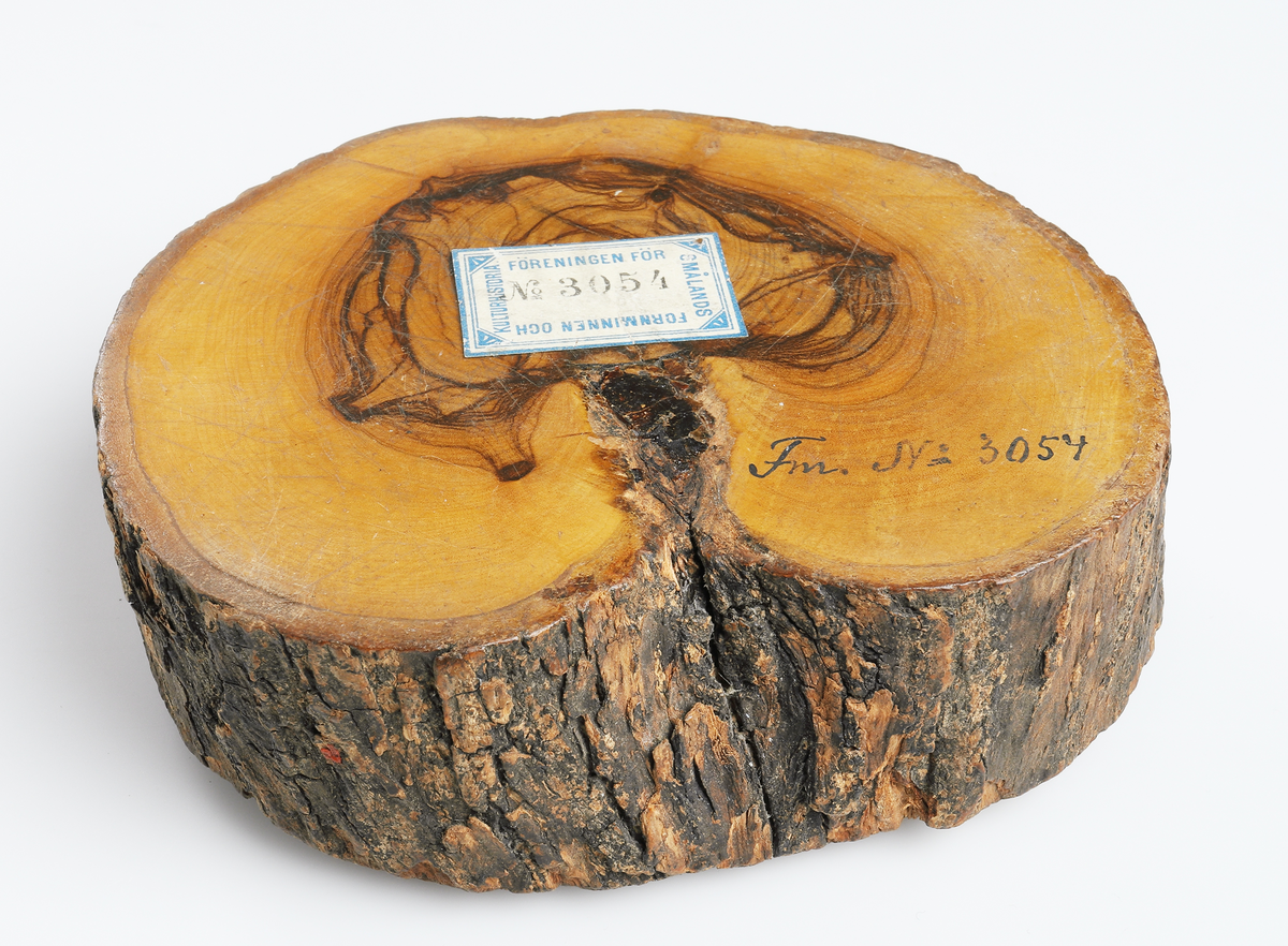 Träskiva av olivträ med utskuren Kristusbild med korsets fana. Nedtill korstecknade hällar. 

Inskrivet i huvudbok år 1907.