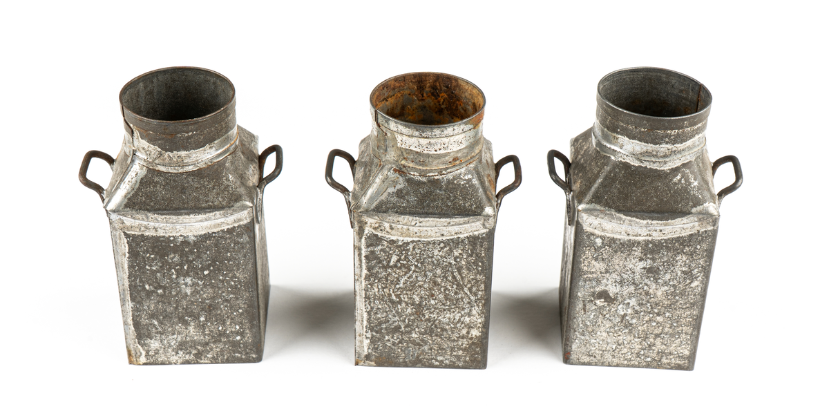 Leksak. Mjölkflaskor, 4 st identiska.
Fyrsidiga med insvängda, raka, partier överst och
hög cylindrisk krage. Bärhänklar på motstående sidor.
Lock saknas på tre  (?).
Ett löst lock med träpackning och lyftögla finns.
Ev. hithörande?. Delarna hoplödda.