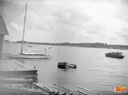 Brygga och en segelbåt i vatten.