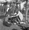 Orientering, 27/9 1942. 
Några ungdomar/funktionärer sorterar något (startkort ?), vid några tallar.