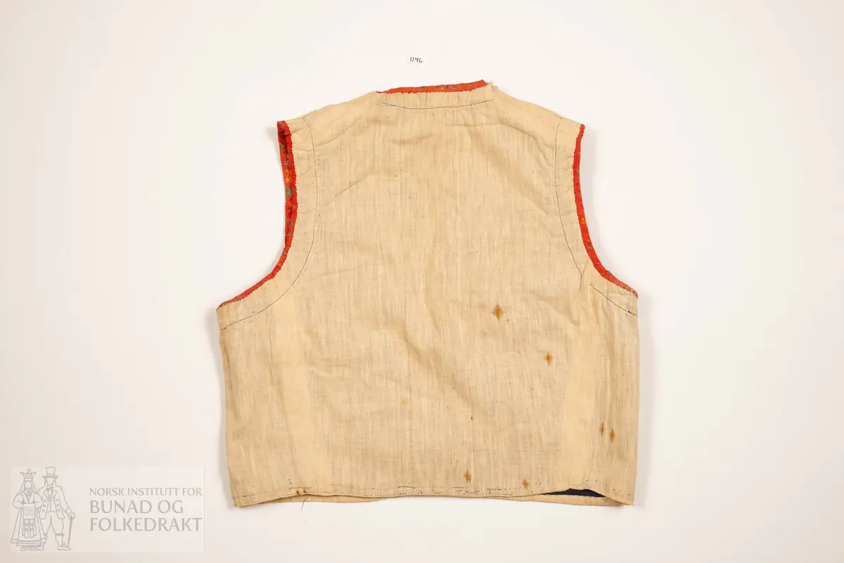 Liv, lapp med "brudeliv 1908".
Liv i blå silkeplysj/langhåra fløyel på bomullsbott kanta med 3,3 cm breie raude silkeband med blomemønstring i raudt, gult, blått og grønt. Innafor ei 1,5 cm agramanblonde.
Sidesaum og skuldersaum er bakoverflytta, rett ringing i hals bak, med snippa som peika nedover. Mjukt forma framkant som møtest i midja.
I framkant, på kvar side, fire maljer festa i stoffet mellom silkeband og agramanblonda, med belegg i bomullslerret på bakside. Første malje er 3,2 cm opp frå nedkant, siste 12,7 cm opp.
19 cm frå nedkanten på det raude silkebandet er ei stor bore (4 cm bred). Løv mangla.
På innsida ein glissen, naturfarga bomullslerret. Kanta rundt til framsida.
Vrangsydd fôr i side- og skuldersauma; maskinsauma.
Raudt band er maskinsauma i ytterkant; ellers er livet berre handsauma.
I livhøgde to små, sekundære hemper og hekter.