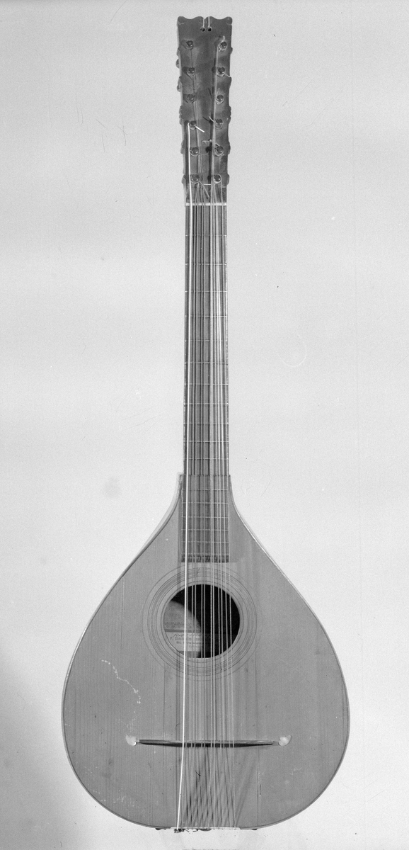 Cister med päronformad hals och ett runt resonanshål. Lång hals. Tolv stämskruvar i ett huvud som är platt. Inte som på en fiol. 