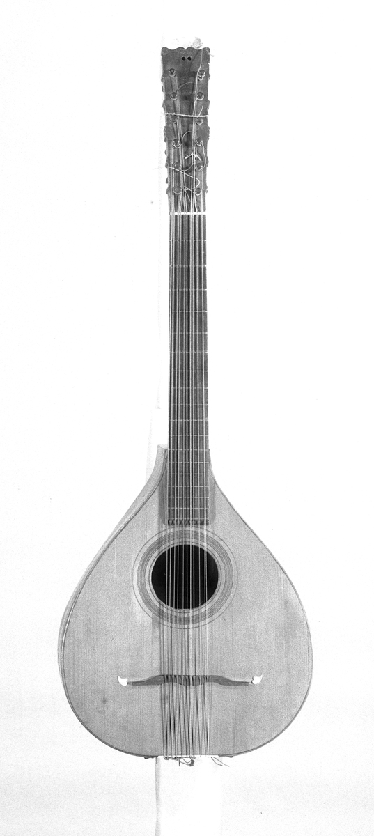 Cister med päronformad hals och ett runt resonanshål. Lång hals. Tolv stämskruvar i ett huvud som är platt. Inte som på en fiol. 