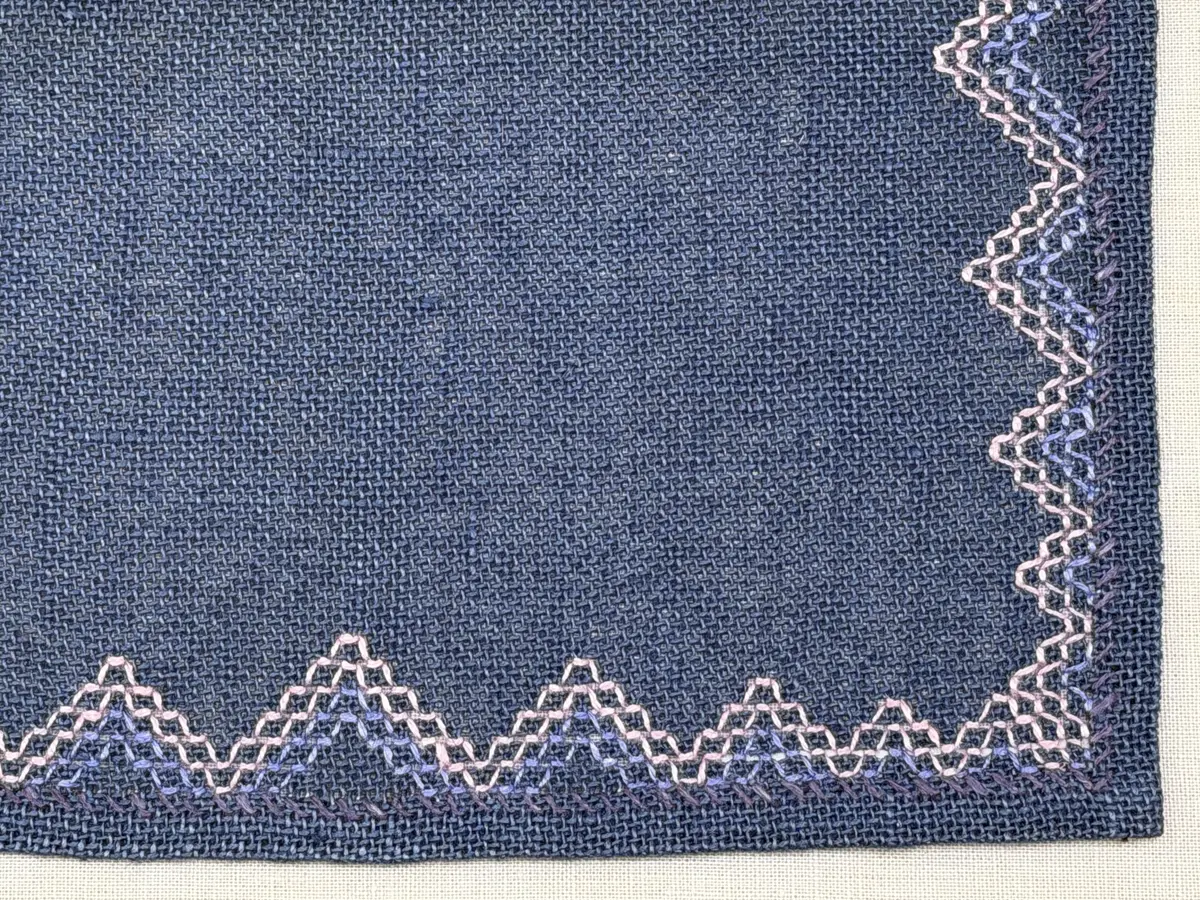 Bordsduk gjord av linneväv med 7,5tr/cm i tuskaft och broderi utfört med lintråd i edasöm och halva korsstygn sydda över tre trådar. Duken har 9mm bred dubbelvikt fåll runt om och raka hörn sömmade med kaststygn.
