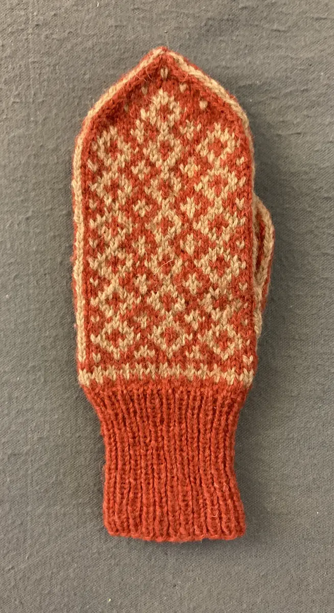 Mönsterstickad barnvante.