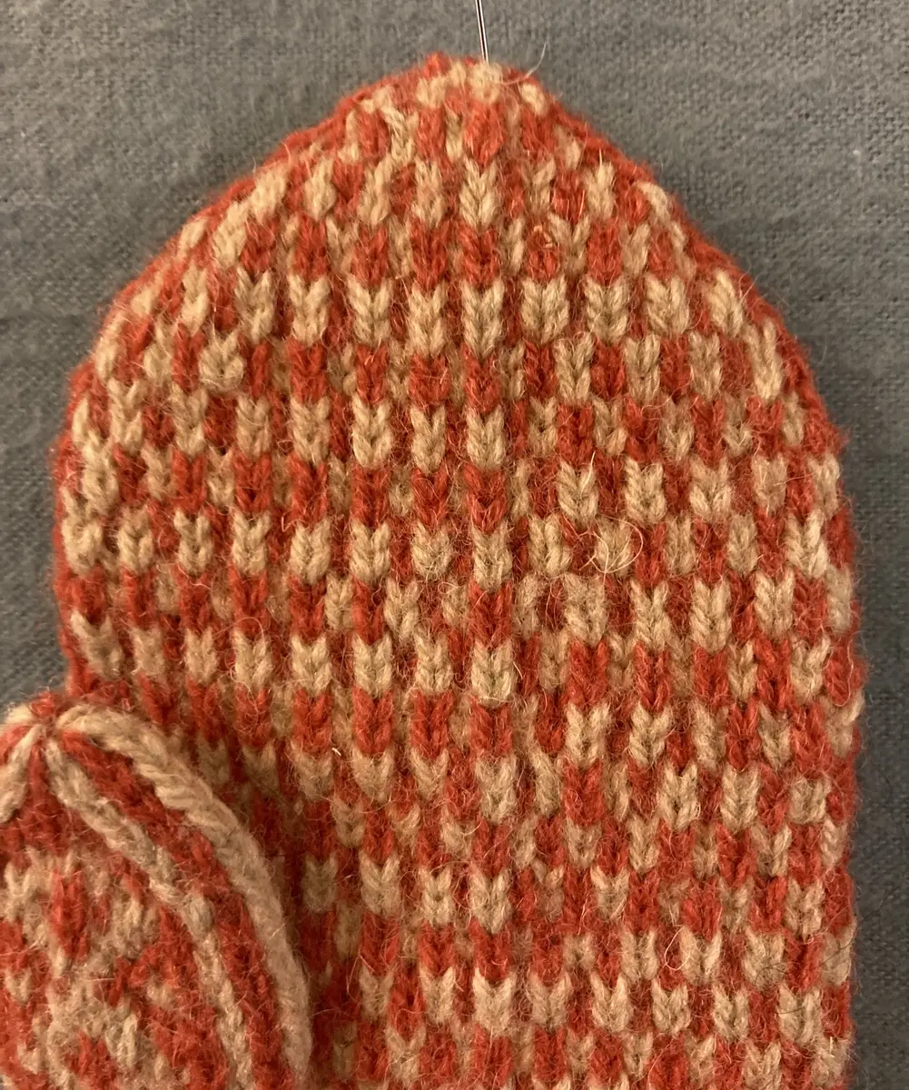 Mönsterstickad barnvante.