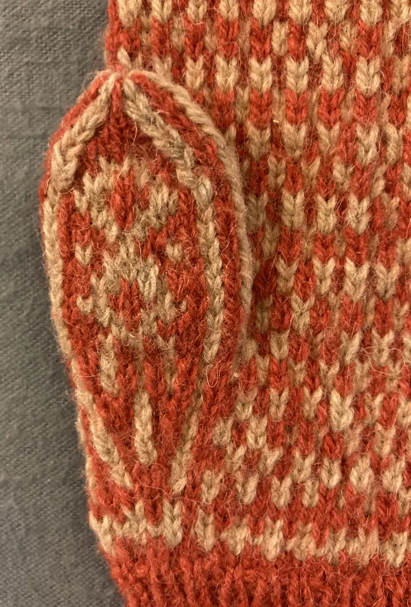 Mönsterstickad barnvante.