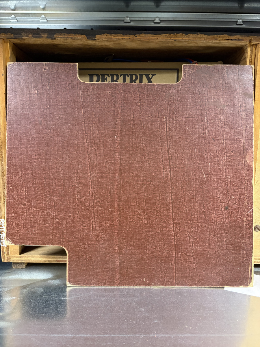 Rektangulær brun radio. Forside til høyre: skala med fem funksjons- og søkeknapper. Til venstre høyttaler med trekk av tekstil. Baksiden har forskjellige uttak.