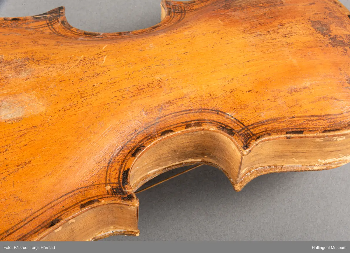 a) fele, b) bue, c) felekasse.  Bjerk, meget defekt resonanskasse.  Oversiden brukket i 3 løse deler.  Et stort stykke mangler.  Resonansbunnen lakkert, har malte profiler.  Har bare tre strenger.  Mangler flere nøkler.  Halsen avsluttes med utskåret løvehode.  Rød og gul ullsnor med dusk bundet fast til løvehodet.  Fingerbrettet har ingen gradering.  
b) Buen en rund pinne av gran.  I den ene enden skåret i L-form.  Feste for buestreng.  Strengen defekt.  I den andre enden er en takket jernbit festet i en snor.   Utsåret bjerkekloss festet i jerntråd.  
c) Gran, skåret.  Selve kassen består av et bredt bord, bøyd til hesteskoform og avsluttet med fire fjær til sinking i hver ende.  Sluttstykke mangler.  Bunnen laget av ett bord.  Festet til veggen med fire jernbeslag utvendig og en lærbit som erstatter et beslag.  Dette pluss ett av de andre beslagene går tvers over veggen og danner hengsler for lokket som er laget av ett bord, svakt hvelvet.   Liten k jernkrampe i lokk-kanten.  Tilsvarende i veggen.  Beslaget  på toppen av "hesteskoen" har en liten jernkrampe med jernring.  Lokk og vegger er overmalt.  Bunnfarge brun.  Veggen akantus i gult, sort , blått og hvitt.  Beslagene blåmalt.  På samme side som jernkrampe bokstaver og tall malt med gult:  KITTIL HARALSSEN 1843.  Veggen har to store hull.  Lokket har blomsterdekor i samme farge som veggene.  Innvendig brunmalt.  Stort stykke spikket bort.  18/8-64. Å Astrup

Fela er nå restaurert og satt i full stand. 5/3-1979, K.K.Nøklebye