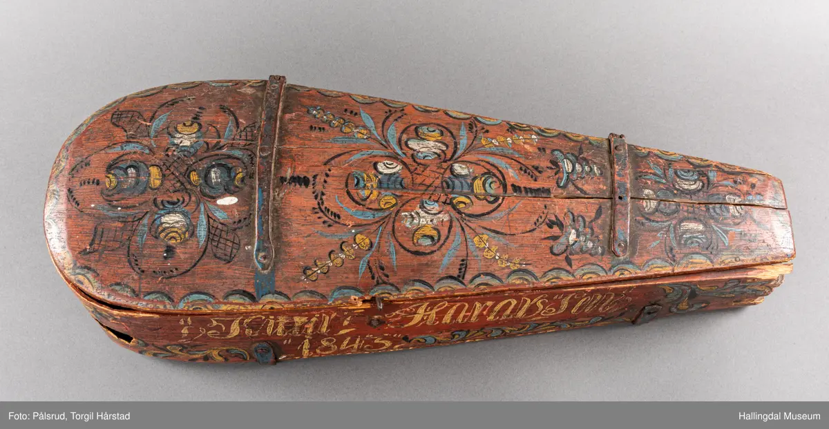 a) fele, b) bue, c) felekasse.  Bjerk, meget defekt resonanskasse.  Oversiden brukket i 3 løse deler.  Et stort stykke mangler.  Resonansbunnen lakkert, har malte profiler.  Har bare tre strenger.  Mangler flere nøkler.  Halsen avsluttes med utskåret løvehode.  Rød og gul ullsnor med dusk bundet fast til løvehodet.  Fingerbrettet har ingen gradering.  
b) Buen en rund pinne av gran.  I den ene enden skåret i L-form.  Feste for buestreng.  Strengen defekt.  I den andre enden er en takket jernbit festet i en snor.   Utsåret bjerkekloss festet i jerntråd.  
c) Gran, skåret.  Selve kassen består av et bredt bord, bøyd til hesteskoform og avsluttet med fire fjær til sinking i hver ende.  Sluttstykke mangler.  Bunnen laget av ett bord.  Festet til veggen med fire jernbeslag utvendig og en lærbit som erstatter et beslag.  Dette pluss ett av de andre beslagene går tvers over veggen og danner hengsler for lokket som er laget av ett bord, svakt hvelvet.   Liten k jernkrampe i lokk-kanten.  Tilsvarende i veggen.  Beslaget  på toppen av "hesteskoen" har en liten jernkrampe med jernring.  Lokk og vegger er overmalt.  Bunnfarge brun.  Veggen akantus i gult, sort , blått og hvitt.  Beslagene blåmalt.  På samme side som jernkrampe bokstaver og tall malt med gult:  KITTIL HARALSSEN 1843.  Veggen har to store hull.  Lokket har blomsterdekor i samme farge som veggene.  Innvendig brunmalt.  Stort stykke spikket bort.  18/8-64. Å Astrup

Fela er nå restaurert og satt i full stand. 5/3-1979, K.K.Nøklebye