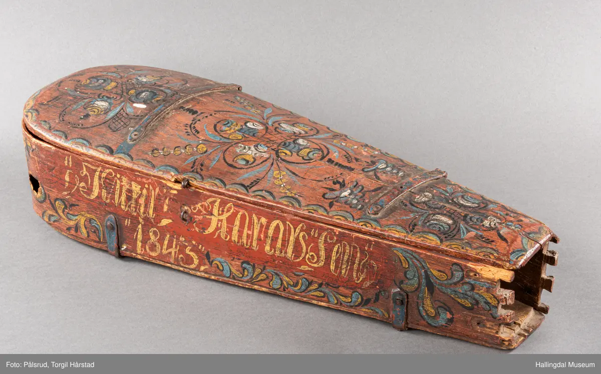 a) fele, b) bue, c) felekasse.  Bjerk, meget defekt resonanskasse.  Oversiden brukket i 3 løse deler.  Et stort stykke mangler.  Resonansbunnen lakkert, har malte profiler.  Har bare tre strenger.  Mangler flere nøkler.  Halsen avsluttes med utskåret løvehode.  Rød og gul ullsnor med dusk bundet fast til løvehodet.  Fingerbrettet har ingen gradering.  
b) Buen en rund pinne av gran.  I den ene enden skåret i L-form.  Feste for buestreng.  Strengen defekt.  I den andre enden er en takket jernbit festet i en snor.   Utsåret bjerkekloss festet i jerntråd.  
c) Gran, skåret.  Selve kassen består av et bredt bord, bøyd til hesteskoform og avsluttet med fire fjær til sinking i hver ende.  Sluttstykke mangler.  Bunnen laget av ett bord.  Festet til veggen med fire jernbeslag utvendig og en lærbit som erstatter et beslag.  Dette pluss ett av de andre beslagene går tvers over veggen og danner hengsler for lokket som er laget av ett bord, svakt hvelvet.   Liten k jernkrampe i lokk-kanten.  Tilsvarende i veggen.  Beslaget  på toppen av "hesteskoen" har en liten jernkrampe med jernring.  Lokk og vegger er overmalt.  Bunnfarge brun.  Veggen akantus i gult, sort , blått og hvitt.  Beslagene blåmalt.  På samme side som jernkrampe bokstaver og tall malt med gult:  KITTIL HARALSSEN 1843.  Veggen har to store hull.  Lokket har blomsterdekor i samme farge som veggene.  Innvendig brunmalt.  Stort stykke spikket bort.  18/8-64. Å Astrup

Fela er nå restaurert og satt i full stand. 5/3-1979, K.K.Nøklebye