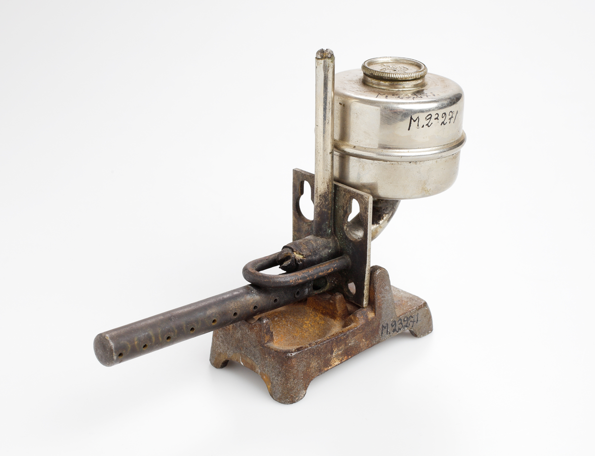 Strykjärn, pressjärn, med oljebehållare för uppvärmning. Trähandtag.

Inskrivet i huvudkatalog 1975.