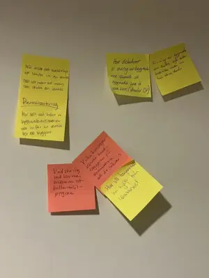 Gula och en röd post-it lappar med text på.