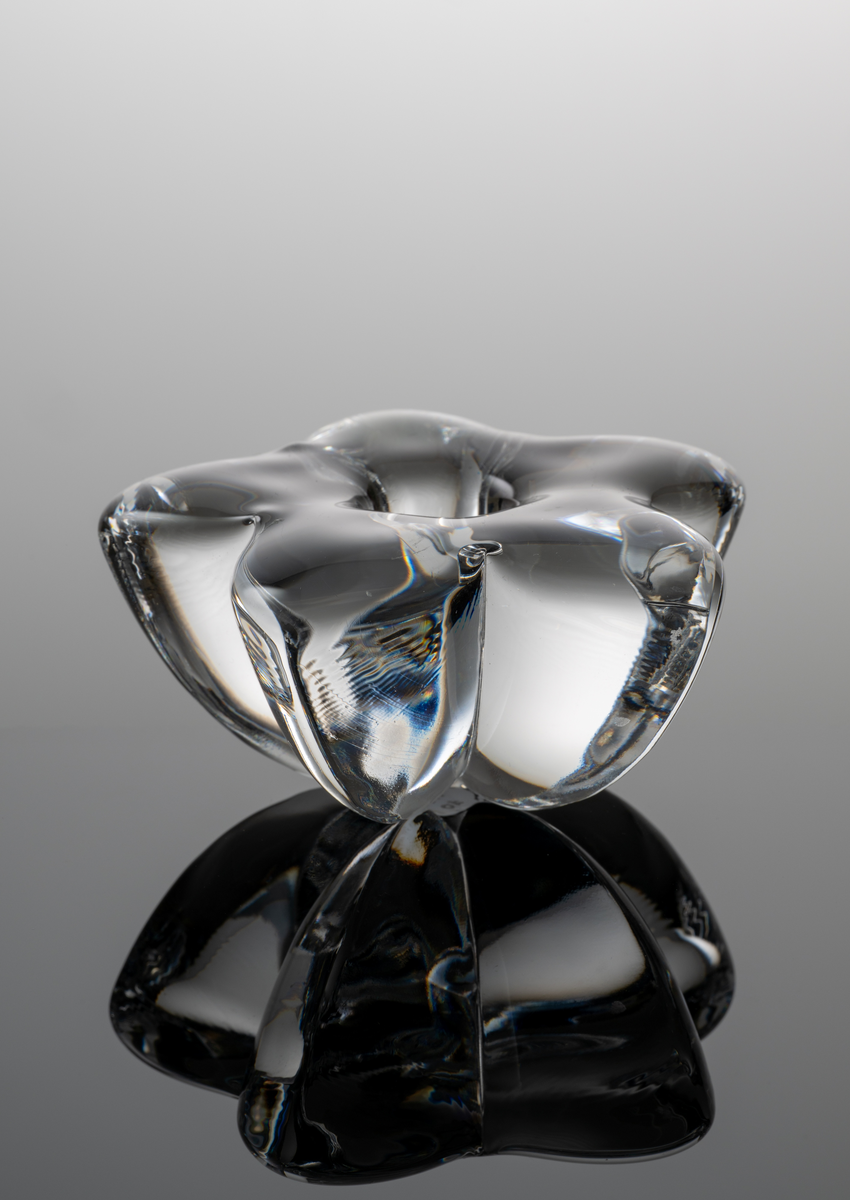 "Stella" Formgivare: Lars Hellsten. Ljusstake i tjockt klarglas med femuddig omvänt konande form.