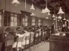 Malmö Telefonstn. År 1905. Lokala telefonsalen. Stående fr.v. vf Frida Norling och kr Oscar Eklund. Baskom denne skymtar itf Gerda Vinberg vid nummerbyrån.