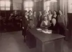 Mjölby Telefonstation omkr. år 1925-30. Gruppbild. Sittande fr.v. rtf Nora Carlsson f Johansson, tk G. Dahlin. Ståede fr.v. rtf Ingeborg Andersson f Johansson, ltf Alma Johansson ( syster till föreg. ), rtf Britta Muhrman, ltf Andrea Johansson f Nylén, eltf Karin Pettersson, rtf Ellen Johansson f Lindholm, rtf Elsa Holm f Lindén, rtf Iris Blomkvist. Vid växelborden fr.v. rtf Sara Ekedal f Åberg, lntf Maggie Bodin, ltf Tyra Carlsson.