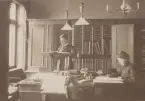 Malmö Telegrafstation år 1905. Telegrafdirektörsexp. Den manlige är telegrafassistent A.W. Persson och den kvinnliga telefonist Signe Ekström. Det lilla bordet var vaktmästare Lindvalls plats.