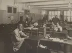 Stockholm Telegrafstation. Gruppfoto. Personal. Ass K.J.A. Svensson, ass Einar Leander (främst på bilden), ass O.R. Sundbom, tgx M.E. Wedholm, tgx V.E. Pehrson född Jansson, ass N.T. Roos, tgx S.T.E.A Langborger född Gyllenholm, sb K.E.S. Lund, kr B.F.J. Berner ?, ass K.E.R. Malmgren, tgx S. Fallenius född Dahlgren, sb G.J. Andersson, tgx E.J. Karlöf.
