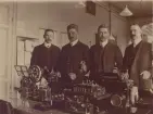 Stockholm Telegrafstation år 1910. Murraysystemet. Gruppfoto. Från vänster lf Pettersson, kontrollör E.G. Olsson, uppfinnaren Murray och kontrollör Widstrand.