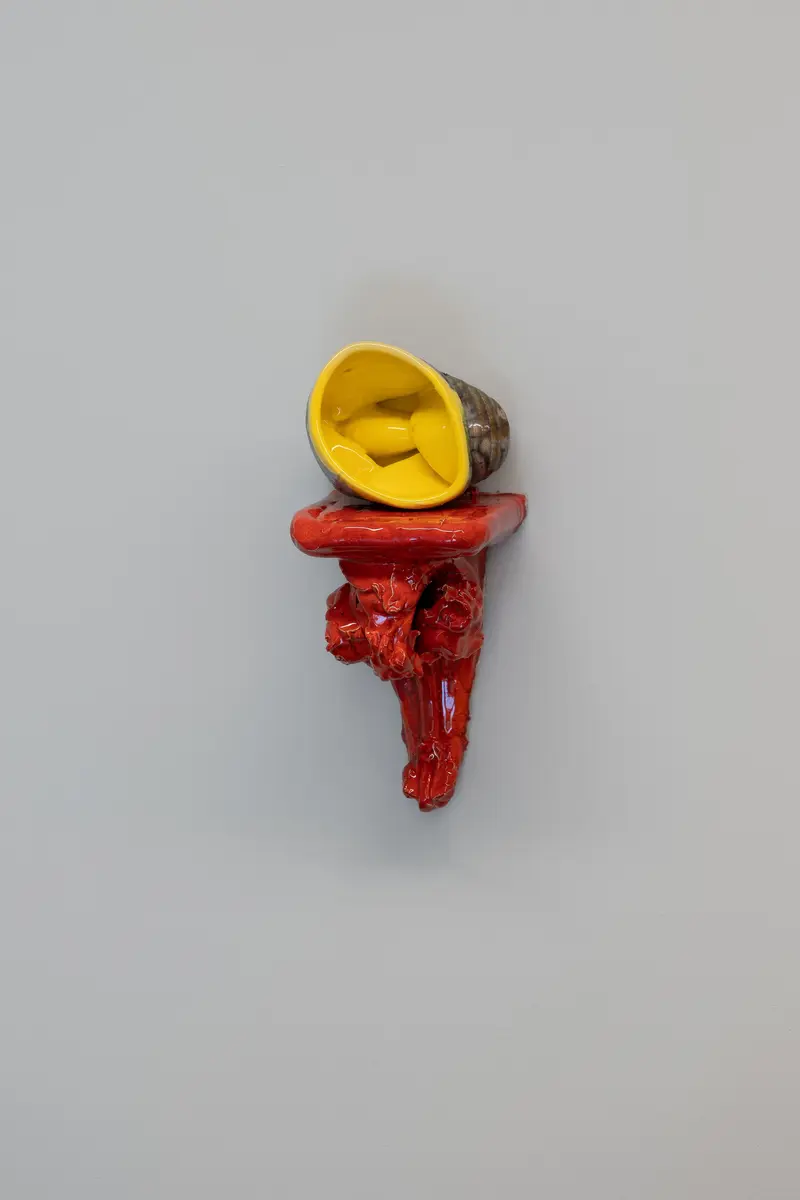 Vridd keramiskobjekt hviler på en veggmontert konsoll.