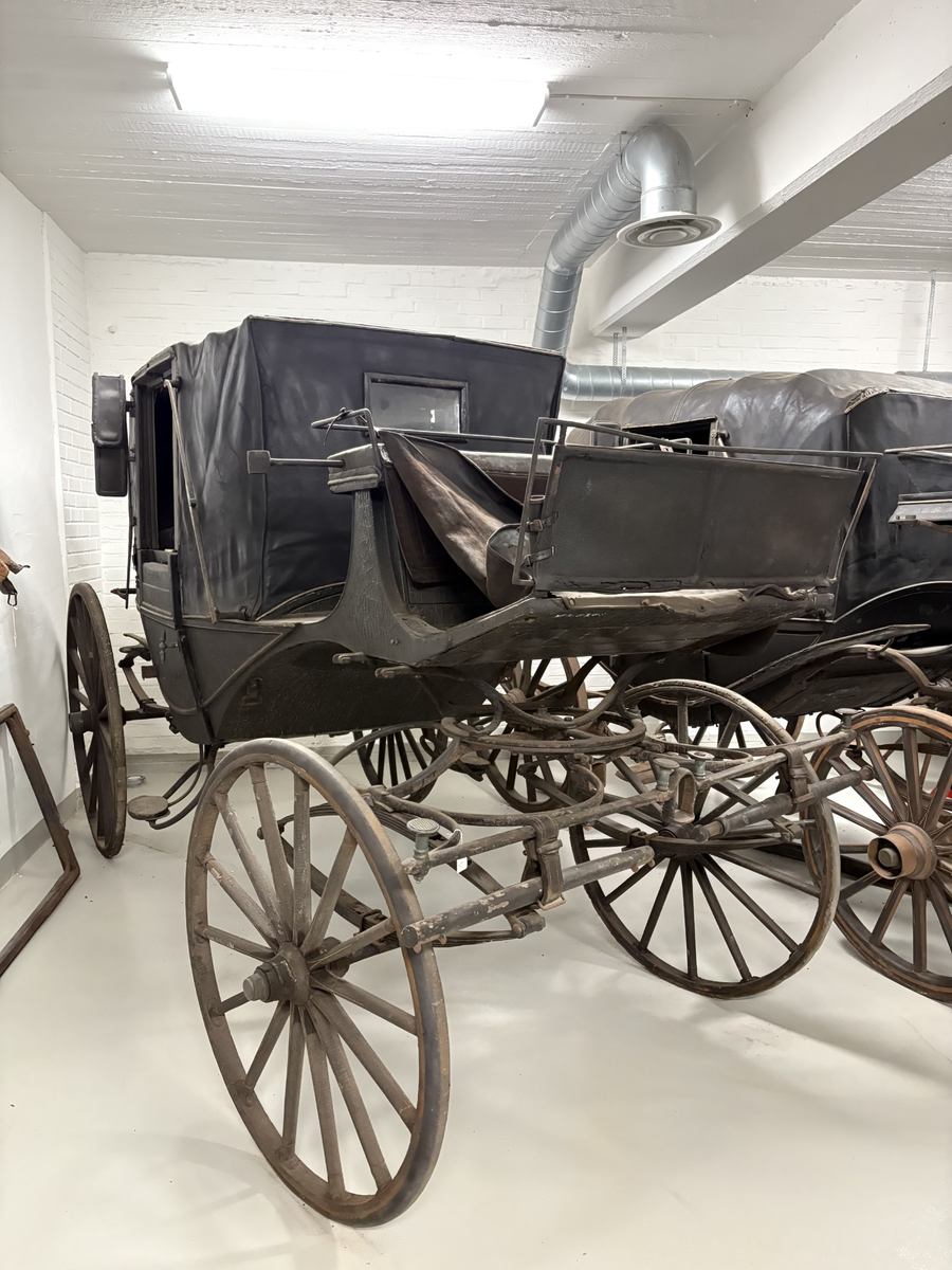 Svartmålad fyrhjulig hästvagn. Vagnen har öppen läderklädd kuskbock men är i övrigt täckt med sufflett. Halva suffletten fälls framåt och halva bakåt.
Kupén har två dörrar och ett mindre fönster framåt och ett runt litet fönster bakåt.  Sätena och dörrarnas insida är klädda med brunt läder. Mässingsbeslag på dörrarna. Kupén har både framåt och bakåt säten. Fotsteg på varje sida. Stänkskydd monterade på kupén. Bakhjulen större än framhjulen.