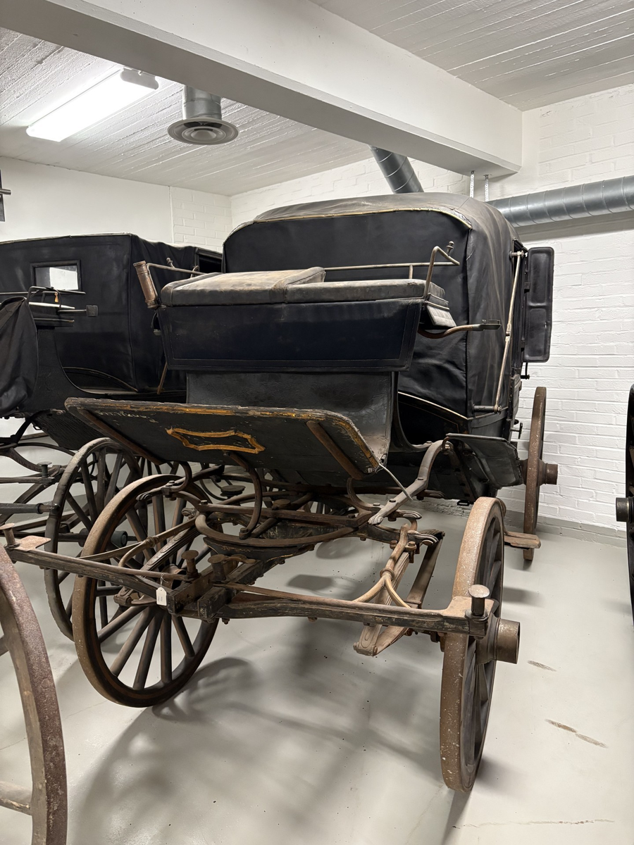 Svartmålad fyrhjulig hästvagn. Vagnen har öppen läderklädd kuskbock men är i övrigt täckt med sufflett. Halva suffletten fälls framåt och halva bakåt.
Kupén har två dörrar och ett mindre fönster framåt och ett runt litet fönster bakåt.  Sätena är klädda med blått tyg. Mässingsbeslag på dörrarna. Kupén har både framåt och bakåt säten. Fotsteg på varje sida. Stänkskydd monterade på kupén. Bakhjulen större än framhjulen.