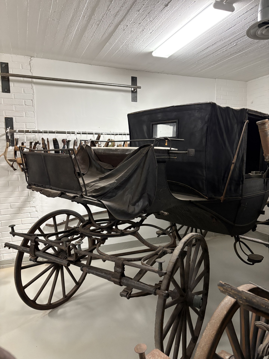 Svartmålad fyrhjulig hästvagn. Vagnen har öppen läderklädd kuskbock men är i övrigt täckt med sufflett. Halva suffletten fälls framåt och halva bakåt.
Kupén har två dörrar och ett mindre fönster framåt och ett runt litet fönster bakåt.  Sätena och dörrarnas insida är klädda med brunt läder. Mässingsbeslag på dörrarna. Kupén har både framåt och bakåt säten. Fotsteg på varje sida. Stänkskydd monterade på kupén. Bakhjulen större än framhjulen.