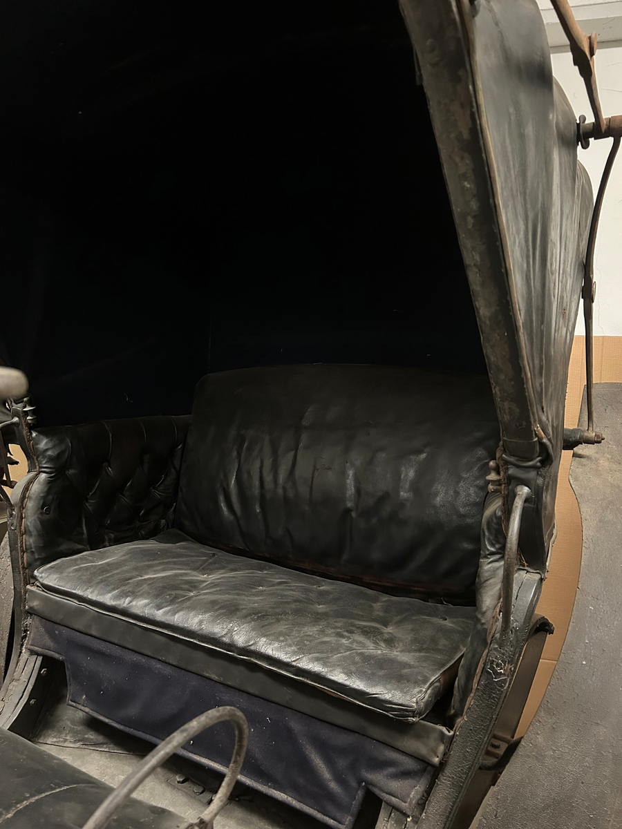 Svartmålad. Fyrhjulig hästvagn. Vagnen har öppen kuskbock med möjlighet att dra sufflett över passagerarplatsen. Huvudsäte för framåtresande men litet klätt nedfällbart säte för bakåtresande. Sätena är klädda med svart skinn. Fotsteg på varje sida.  Två skaklar framtill. Stänkskydd monterade på bakhjulen. Bakhjulen större än framhjulen.