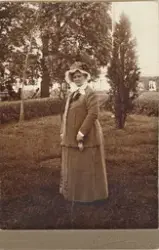 Operasångerskan Christina Nilsson i smalrandig dräkt och lju