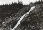 Byggnation av järnvägsbro över Östavallan, Limedsforsen-Särna Järnväg. Brobyggare i förgrunden.