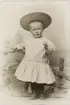 En liten pojke i ljus kolt med stor vit krage och stor stråhatt hos fotografen.
Helfigur. Ateljéfoto.

Trol. Benno Nilsson, son till godsägaren m.m. Johannes Nilsson, Gårdsby.