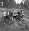 Orientering 1942. 
Sex flickor sitter på en berghäll och studerar kartor.