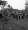 Orientering 1942. 
Samling vid en kontroll, bredvid en grusväg. I bakgrunden skymtar
några bostadshus.