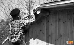 Arnold Kvick bygger en av flera småstugor på järnvägsstation