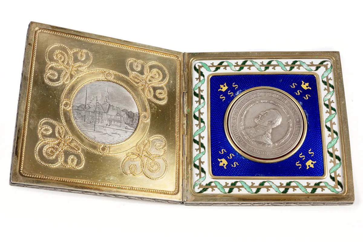 Medalj av silver från Svenska Segelsällskapets jubileumsregatta 1897. På åtsidan kung Oskar II i bröstbild i relief inom stiliserad krans. Frånsidan visar en krönt sköld med "SSS".