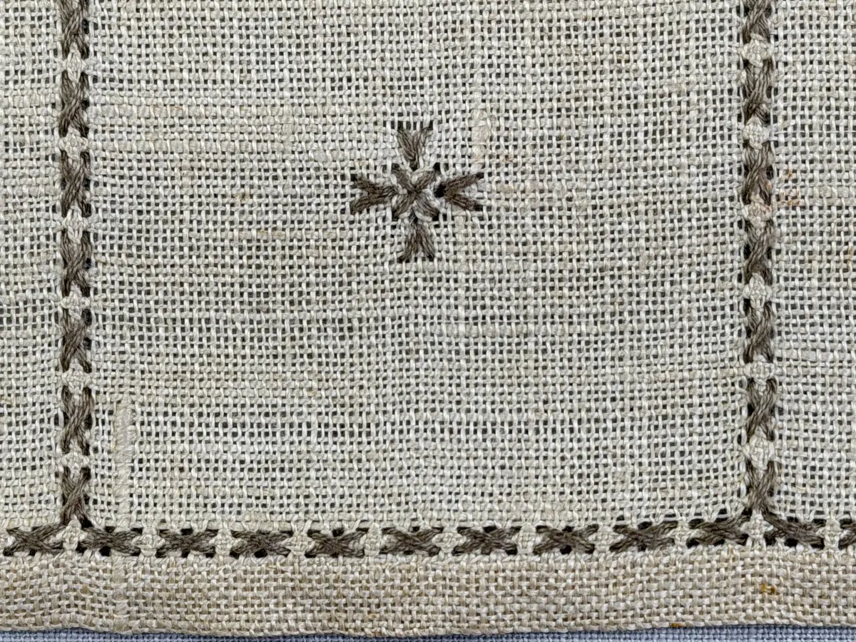 Duk gjord av linneväv med 12tr/cm i tuskaft och broderi utfört med lingarn i myrgång sytt över tre trådar samt moulinègarn i korsstygn och någon typ av tofssöm. Duken har 9mm bred dubbelvikt fåll runt om och sneda hörn fastsydda med kaststygn. 