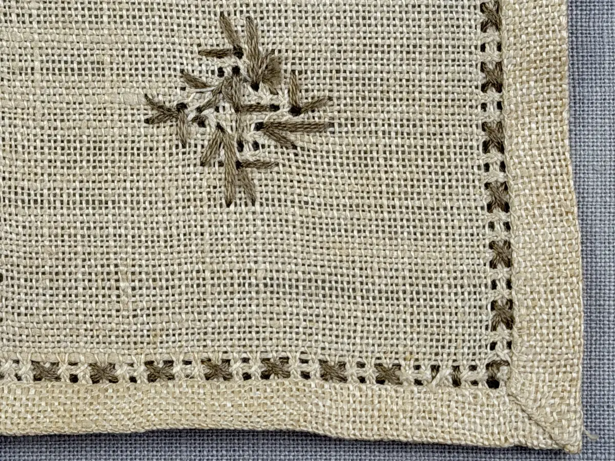 Duk gjord av linneväv med 12tr/cm i tuskaft och broderi utfört med lingarn i myrgång sytt över tre trådar samt moulinègarn i korsstygn och någon typ av tofssöm. Duken har 9mm bred dubbelvikt fåll runt om och sneda hörn fastsydda med kaststygn. 