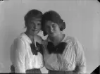 Porträtt av två okända unga kvinnor, de lutar huvudena mot varandra.