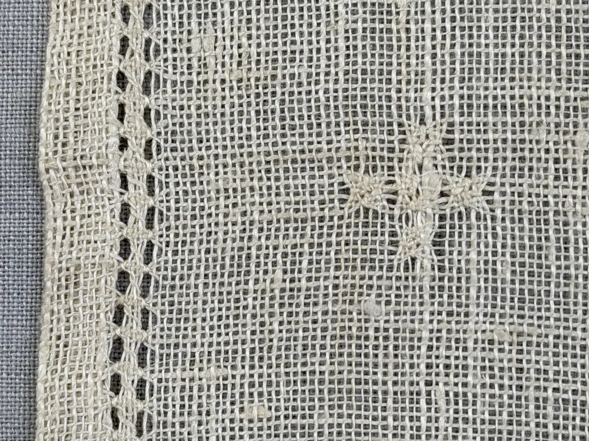 Duk gjord av linneväv med 8tr/cm i tuskaft och broderi utfört med merceriserat bomullsgarn i stoppstygn samt knyppeltråd i slingerstygn och myrgång sydd över fyra trådar. Duken har 9mm bred dubbelvikt fåll runt om och sneda hörn fastsydda med kaststygn.
