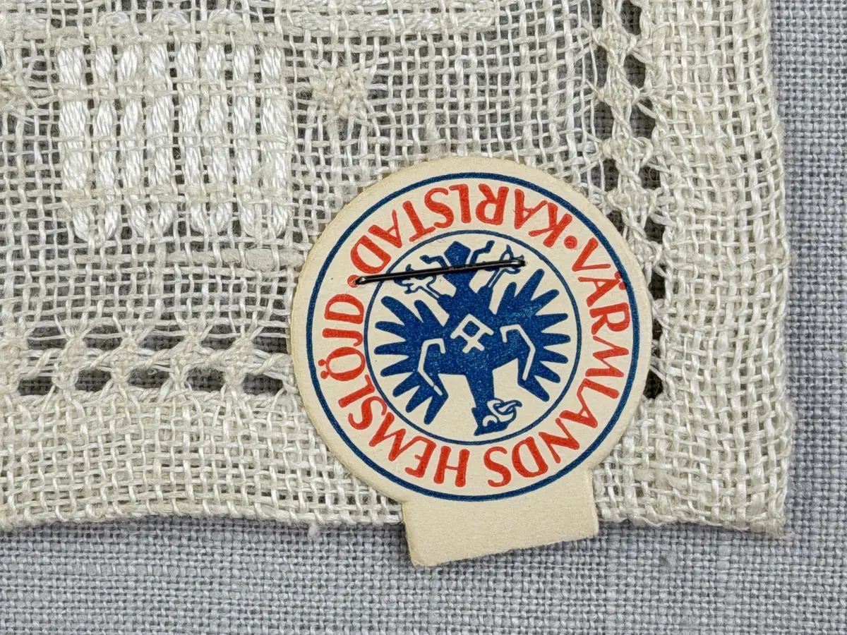 Duk gjord av linneväv med 8tr/cm i tuskaft och broderi utfört med merceriserat bomullsgarn i stoppstygn samt knyppeltråd i slingerstygn och myrgång sydd över fyra trådar. Duken har 9mm bred dubbelvikt fåll runt om och sneda hörn fastsydda med kaststygn.
