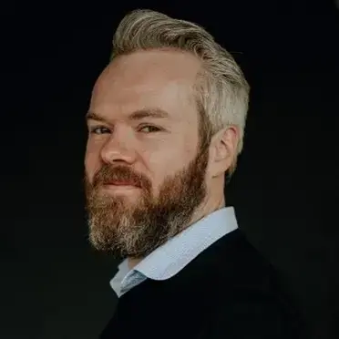 Man med skägg och skjorta.