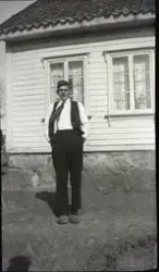 Ein mann står foran eit bolighus.