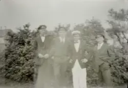 Fire unge menn utendørs, dei har truleg russehuer på seg.