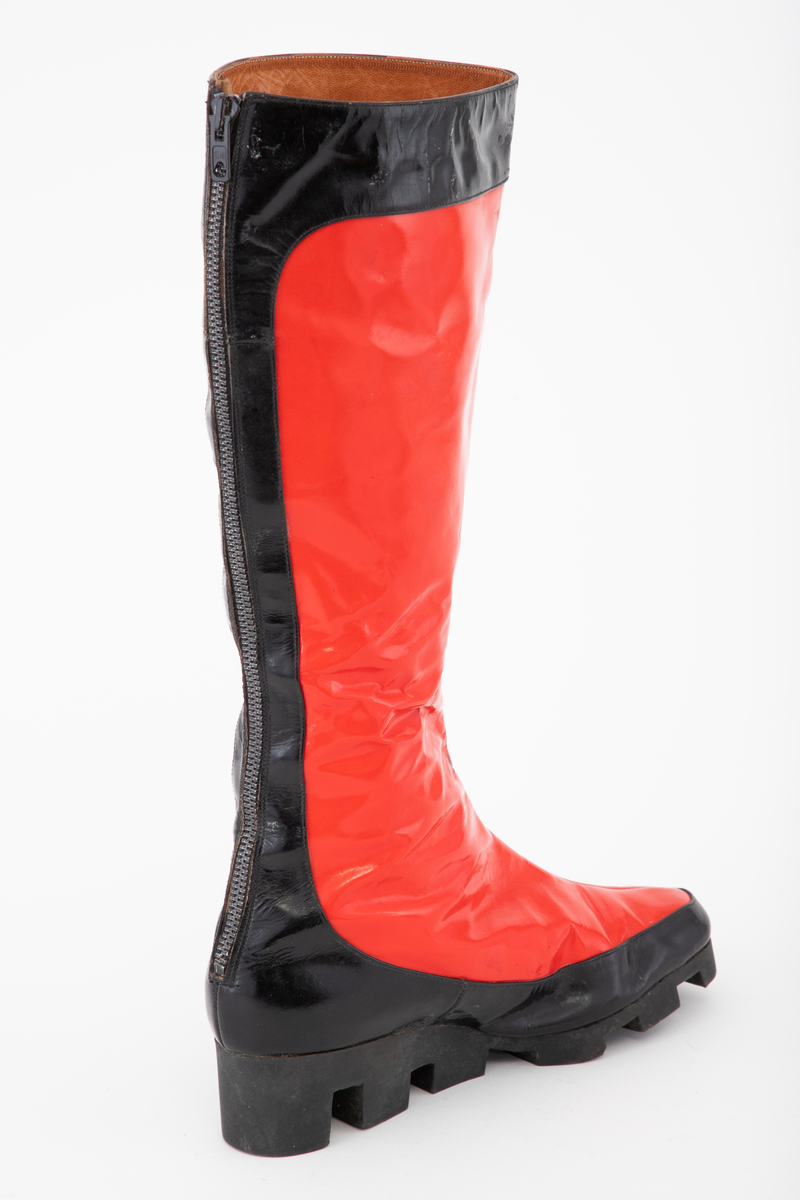 Én venstre, knehøy støvel i rød vinyl med kanting av svart. Kraftig, tagget, svart naturgummisåle og glidelås bak.